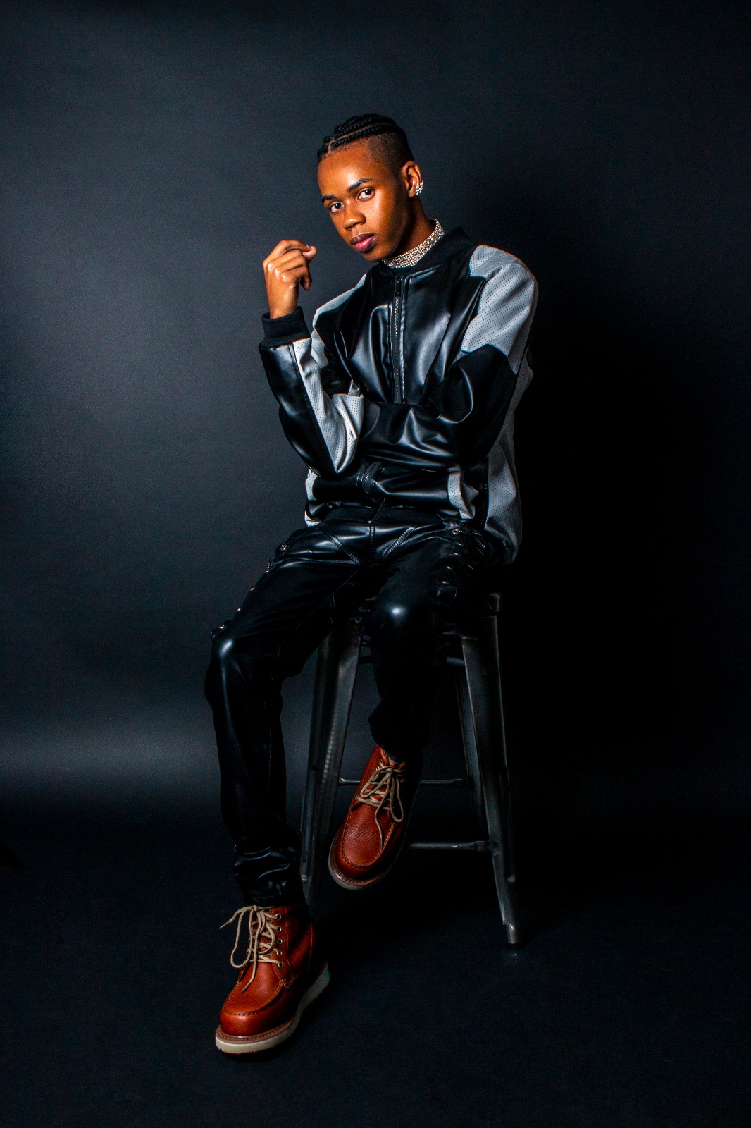 Shilay full body portrait sitting on stool with boots